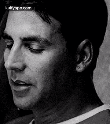 a close up of a man 's face in a black and white photo with his eyes closed .