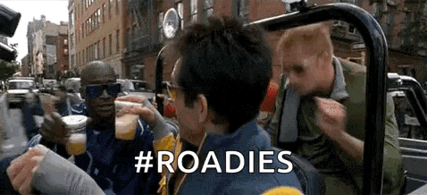 a group of men are sitting in a car drinking beer and talking .