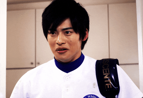 a man wearing a white shirt with a black strap that says descente on it