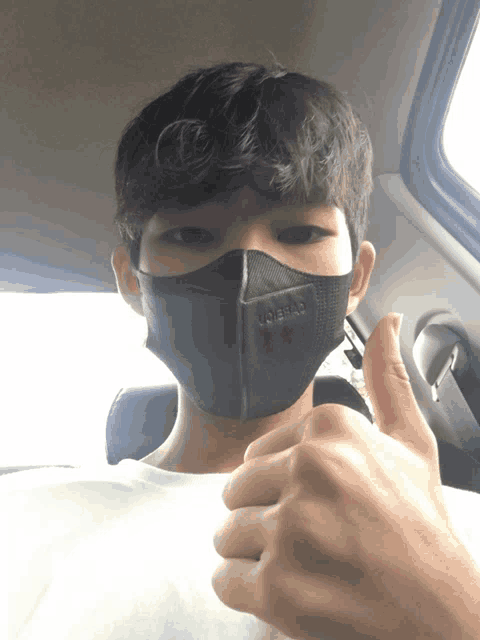 a young man wearing a black face mask with the word libertad on it