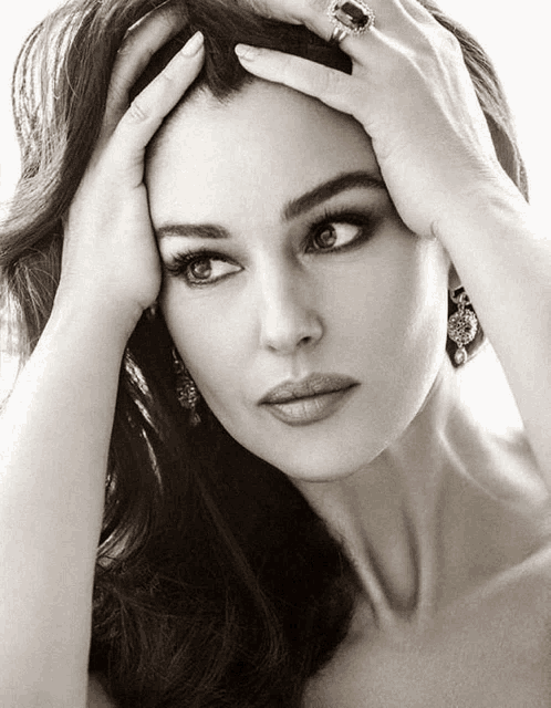 a black and white photo of a woman with her hands on her face