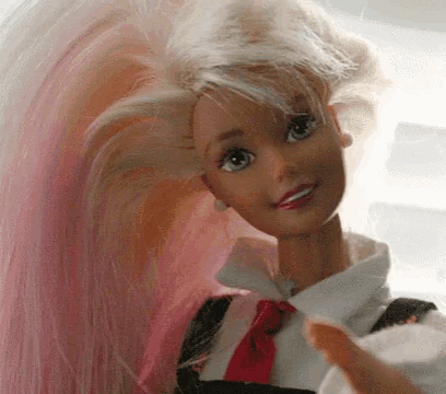 a close up of a barbie doll with pink hair and a red tie