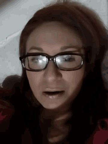 a close up of a woman wearing glasses and making a funny face