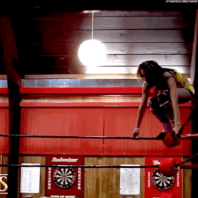 a woman in a wrestling ring with a sign that says budweiser
