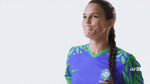 a woman is wearing a blue and green jersey with the word brasil on it