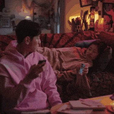 a man in a pink shirt is holding a cell phone with the words " bitch you sounds stupid " on it