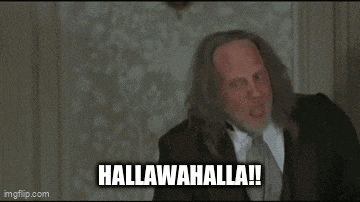 a man in a suit and tie is making a funny face with the words hallawahalla written below him .