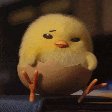 a stuffed yellow chicken is sitting inside of an egg shell