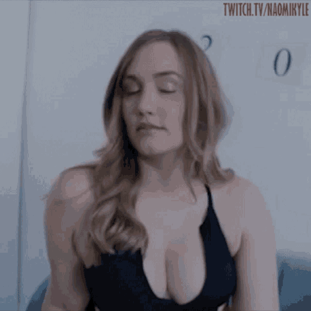 a woman with a very large breast is sitting on a couch .