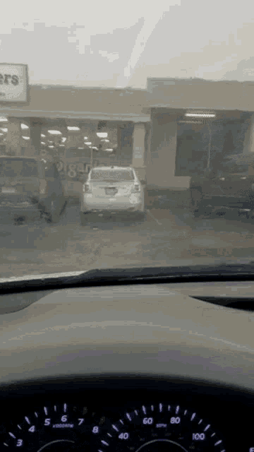 a car is parked in front of a store that has a sign that says flowers