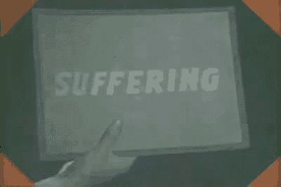 a black and white photo of a person holding a sign that says suffering