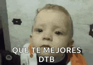 a baby is making a funny face with the words `` que te mejores dtb '' written on it .