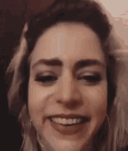 a close up of a woman 's face with a smile .