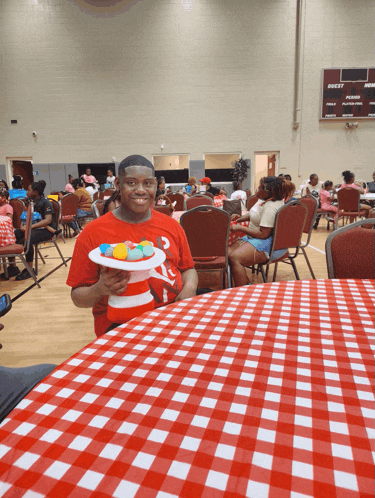 a man in a red shirt holds a plate of food