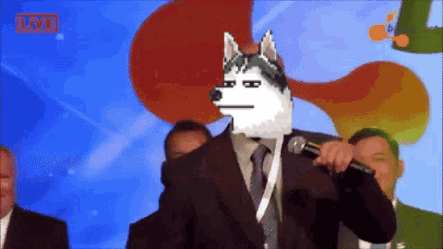 a man in a suit has a husky on his head and a microphone