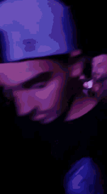 a blurry picture of a man wearing a hat and smoking a cigarette