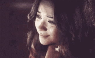 a close up of a woman 's face with tears coming out of her eyes .