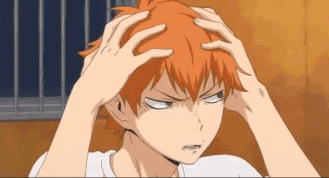 a person with orange hair is holding their head in their hands