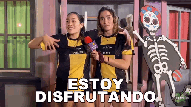 two women standing next to each other with the words estoy disfrutando written on the bottom