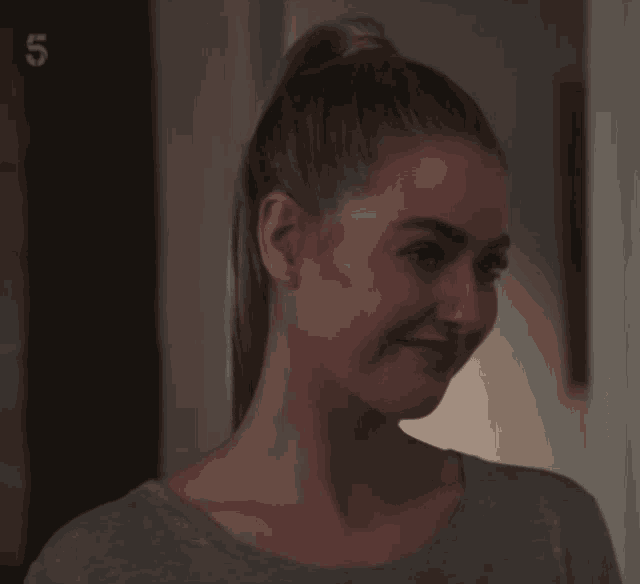 a woman is smiling in front of a door that says 5 on it