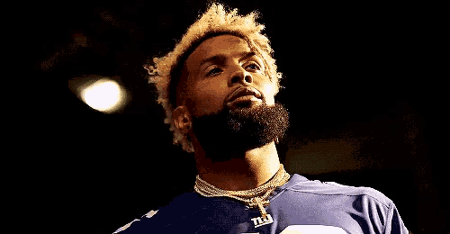 a man with a beard is wearing a new york giants shirt