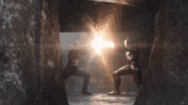a blurred image of two people fighting with a light coming out of the corner