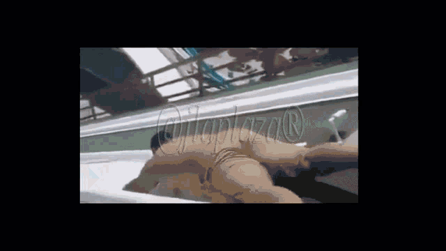 a man is laying on top of another man in a tub with the word plaza on the bottom .