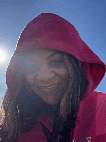 a woman wearing a pink hoodie with the word love embroidered on it