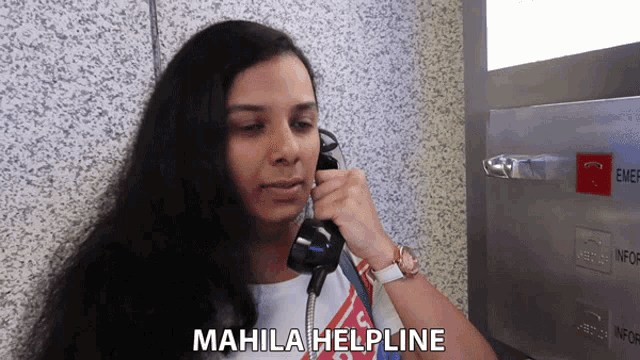 a woman talking on a phone with mahila helpline written on the bottom of her face