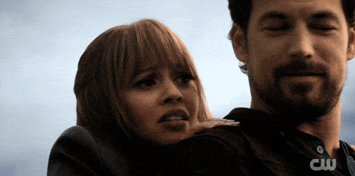 a man holds a woman in his arms with the cw logo visible
