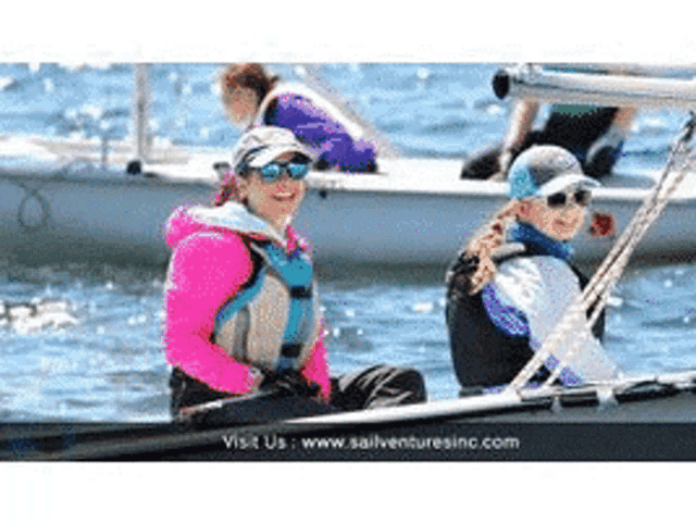 two women are sitting in a boat with the website www.sailventuresinc.com visible