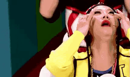 a woman in a yellow jacket is crying while sitting on a chair .