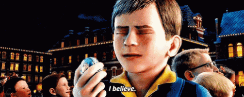 a boy in a yellow shirt is holding a small object in his hand and saying i believe .