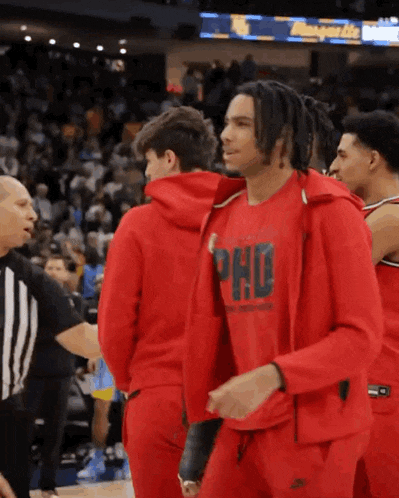 a basketball player wearing a red jacket that says phd on it
