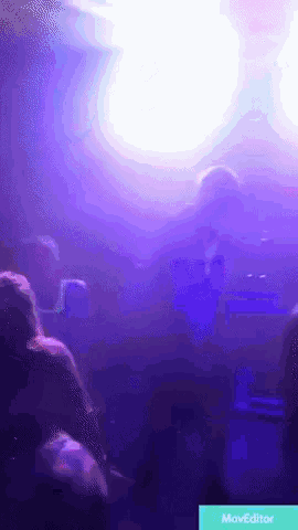 a group of people sitting in a dark room with purple lights behind them and the word moveeditor on the bottom