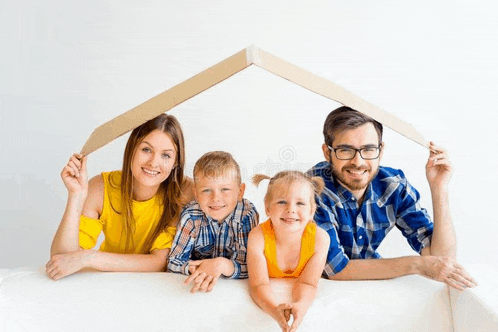 a family is posing for a picture under a cardboard roof .
