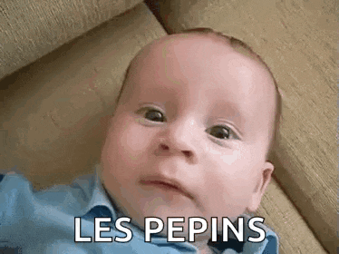 a baby is laying on a couch and making a funny face with the words `` les pepins '' written on it .