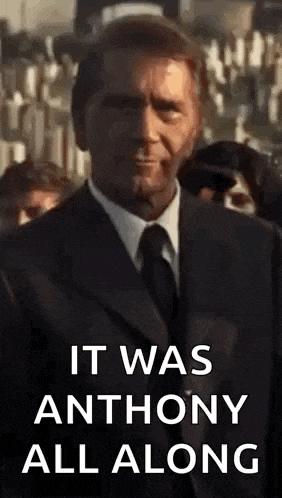 a man in a suit and tie is standing in a crowd .