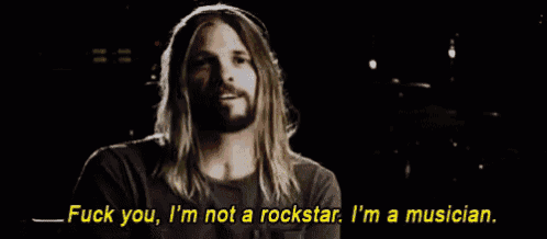 a man with long hair and a beard is saying fuck you i 'm not a rockstar