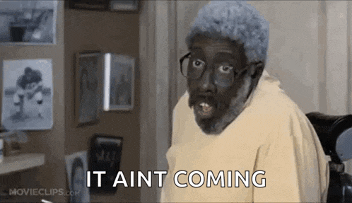 a man with glasses and gray hair is sitting in a chair and says `` it aint coming '' .