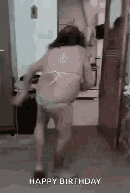 a woman in a bikini is dancing in a kitchen with the words `` happy birthday '' .
