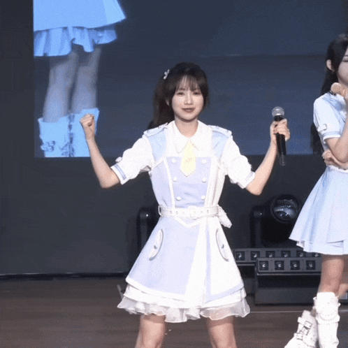 a girl in a white dress holds a microphone