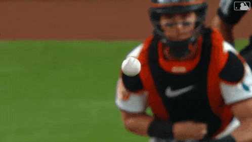 a baseball catcher is catching a ball on the field .