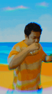 a man wearing a striped shirt is standing on a beach