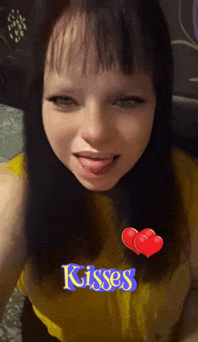 a girl with her tongue sticking out and the word kisses on her shirt