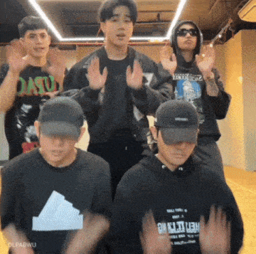 a group of young men are posing for a picture with one wearing a shirt that says ' dasu ' on it