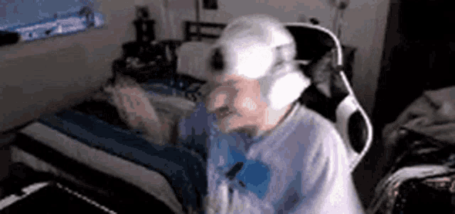 a man wearing headphones is sitting in a chair in front of a bed .