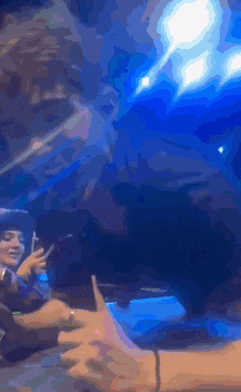 a group of people are sitting at a table in front of a blue light