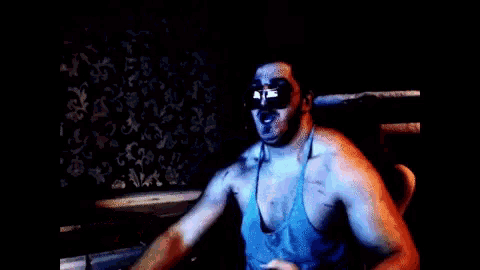 a shirtless man wearing sunglasses and a tank top