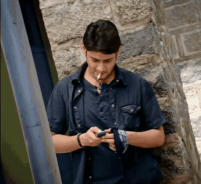 a man in a blue shirt smoking a cigarette
